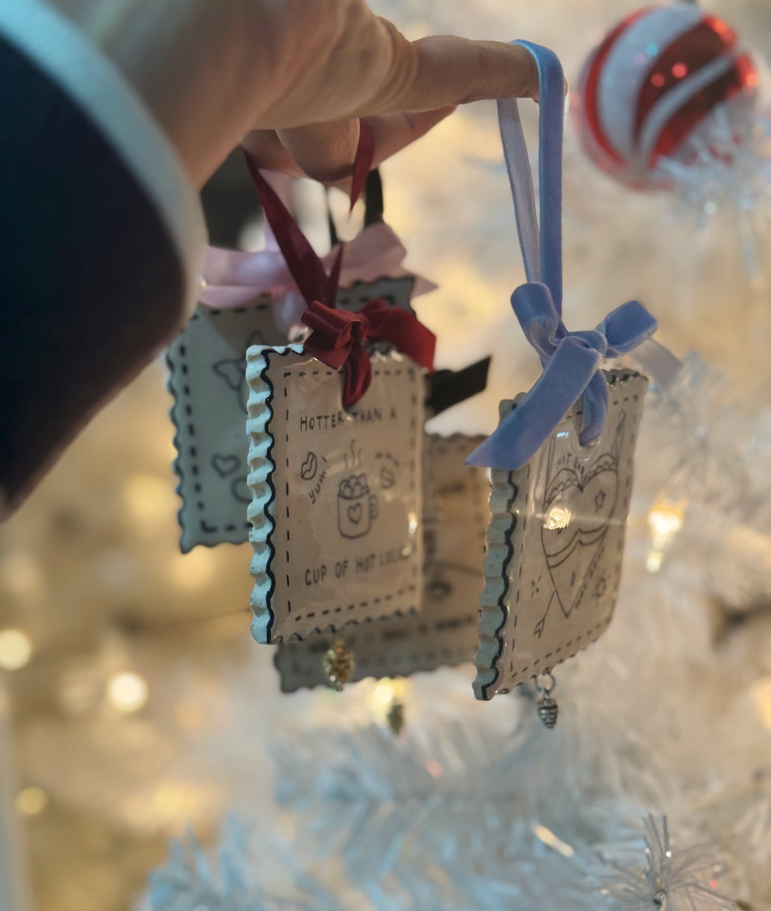 Polymer clay ornaments with ribbon and painted illustrations for christmas trees